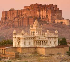 View of the white marble Jaswant Thada memorial with Mehrangarh Fort towering behind it in Jodhpur at sunset, illustrating Jodhpur sightseeing highlights.