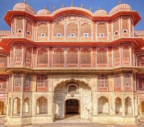 Facade of an ornately decorated pink sandstone palace in Jaipur, illustrating a key sightseeing attraction featured in Jaipur tour packages